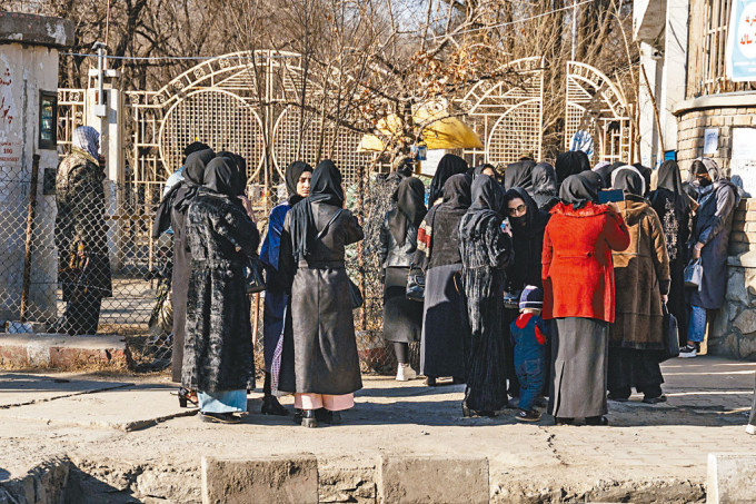阿富汗女大學生周三被保安人員禁止進入校園，站在喀布爾一所私立大學門外。　