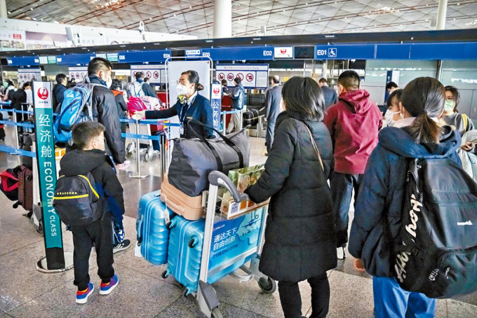 旅客在首都机场办理飞往东京的登机手续。