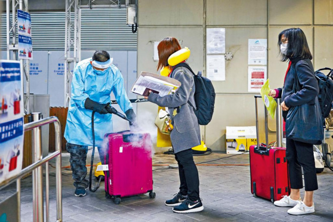抵港者登车前，机场防疫人员消毒行李。