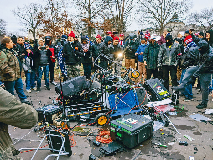■示威者在國會大廈附近推倒記者的器材。