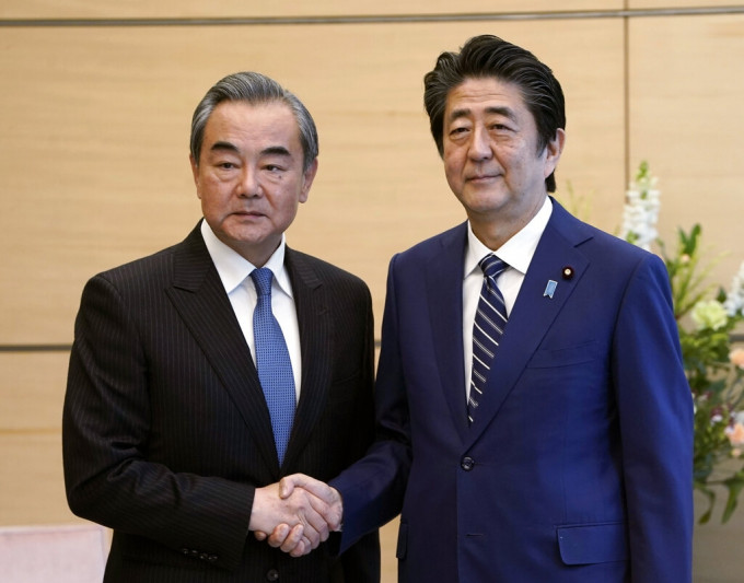 日本首相安倍晉三與到訪的外長王毅會面。 AP圖