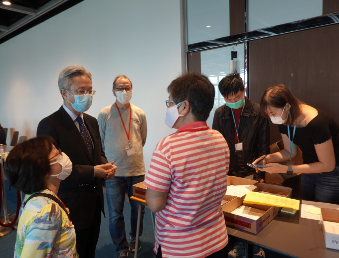 罗智光（左二）今日到访政府资讯科技总监办公室位于香港大会堂的家居检疫控制中心，关心同事应对强制家居检疫人数增加的工作情况。 政府图片