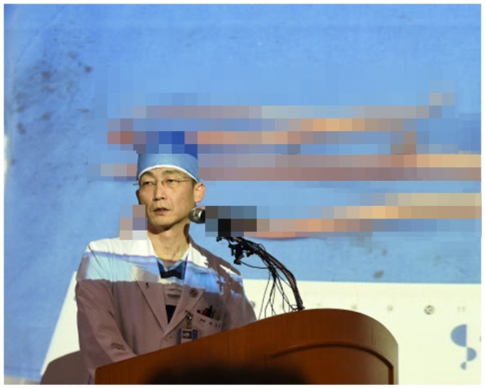负责手术的李国宗教授展示寄生虫图片。网图