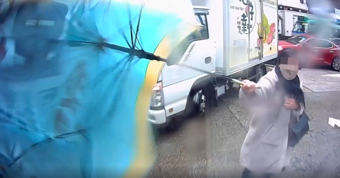 旺角女子過馬路時，雨傘遭鈎實車尾。影片截圖