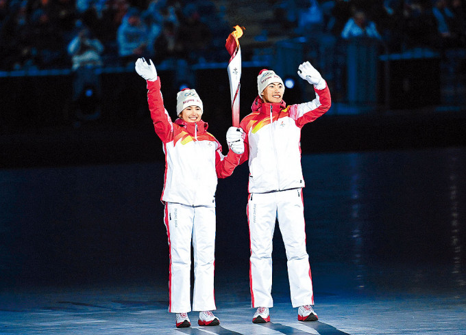 维族的迪妮格尔（左）和汉族的赵嘉文（右）担任冬奥开幕主火炬手。