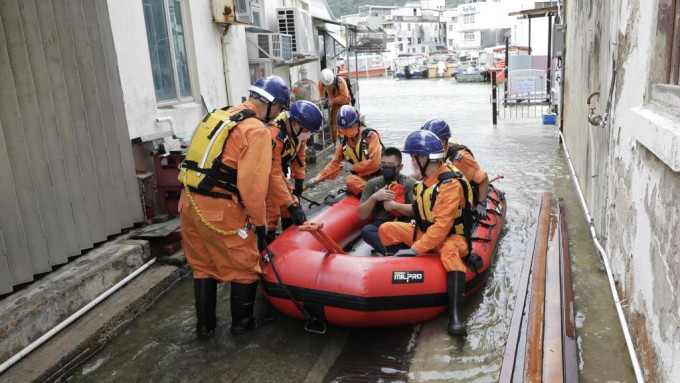 图示民众安全服务队队员在演练中以橡皮艇拯救被围困的居民。政府图片