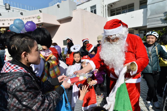 由医护人员扮演的圣诞老人向病人派送圣诞礼物。