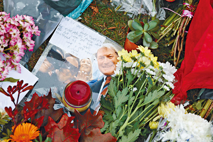 ■民众在埃姆斯遇刺地点摆放鲜花及其相片致哀。