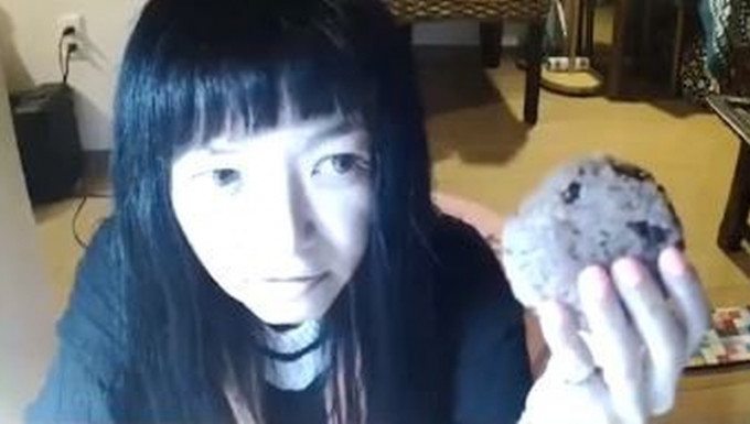 日本女Youtuber，直播中表演「鲸吞拳头咁大的饭团」。(网图)