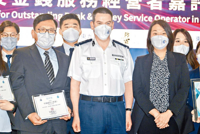 警方东九龙总区副指挥官颜铁诚总警司(中)与获奖者合照。