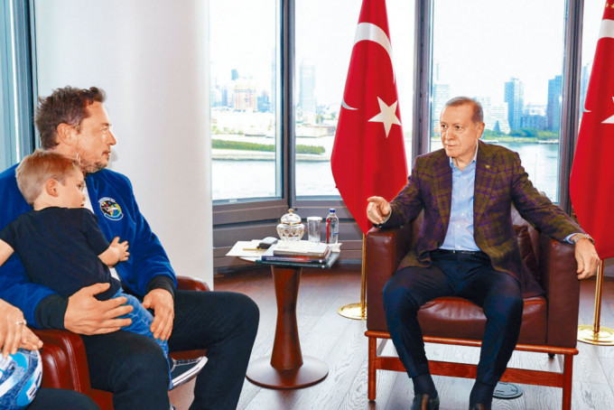 马斯克（左）周日抱着简称「X」的儿子，在纽约与土耳其总统埃尔多安会面。