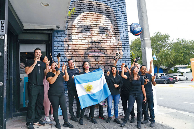 身處邁亞密的市民在美斯的壁畫前，展示阿根廷國旗合照。