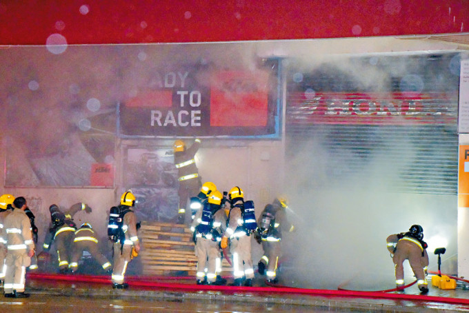 多名消防员进入发生3级火的车房灌救。