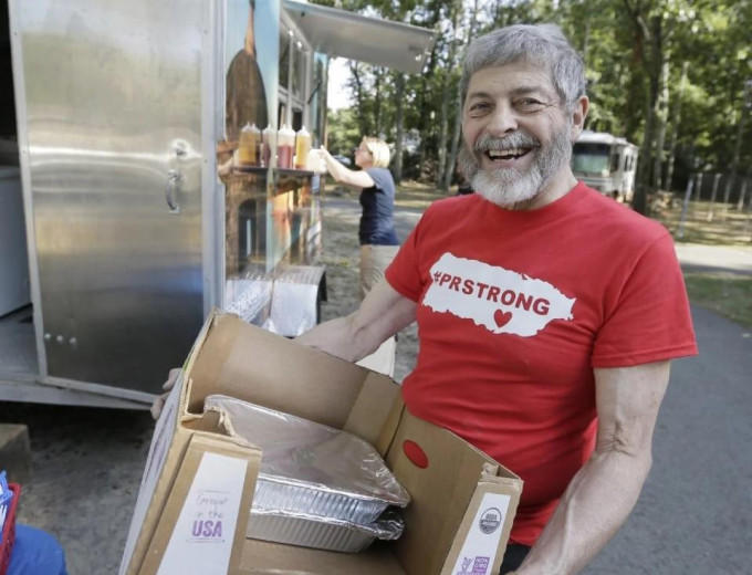 老翁捐出40桶粮食接济风灾灾民。AP图片