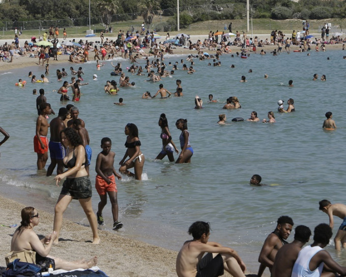 法国南部录破纪录的摄氏45.9度，不少人涌往沙滩消暑。AP