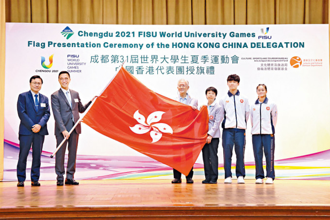 文化体育及旅游局局长杨润雄（左二）授旗，吴诺弘（右二）及王康怡（右）为学生代表。