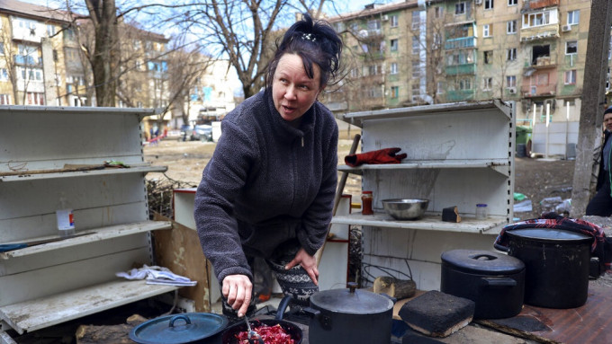 马里乌波尔居民在路边煮食。美联社资料图片