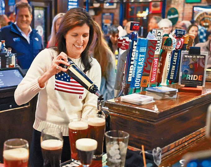 黑利上周六在新罕布什尔州一间酒吧拉票时，倒啤酒入酒杯。