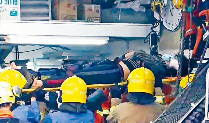 消防员救出受伤被困工人送院。有线电视画面