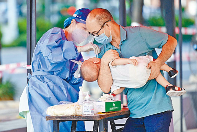 廣西南寧居民帶嬰童核酸檢測。