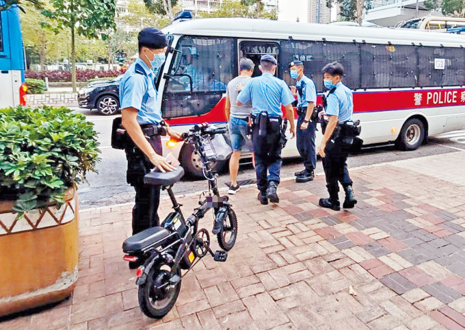 ■警員在將軍澳帶走一名騎電動單車的男子。