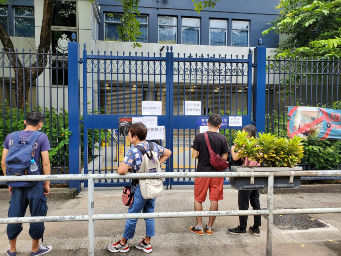 在场声援的人士在葵涌警署门外大闸上张贴标语，内容大致是「释放被捕人士」。 梁国峰摄
