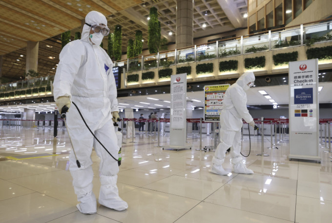 穿著防護服的工作人員在南韓首爾金浦機場噴灑消毒劑，以預防新冠狀病毒。AP