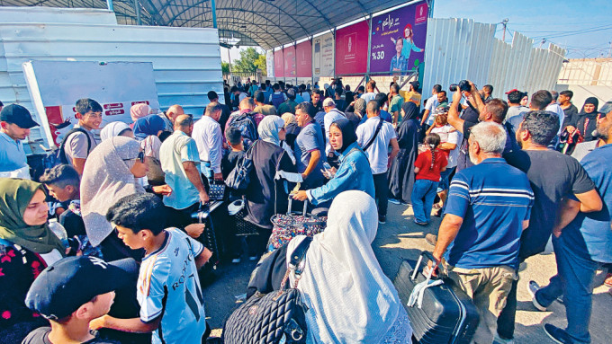 拥有双重国籍的巴勒斯坦人，周三在接壤埃及边境的拉法口岸准备离开加沙。　