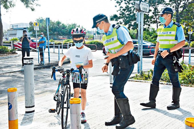■交通警向踩单车小童派发宣传单张。