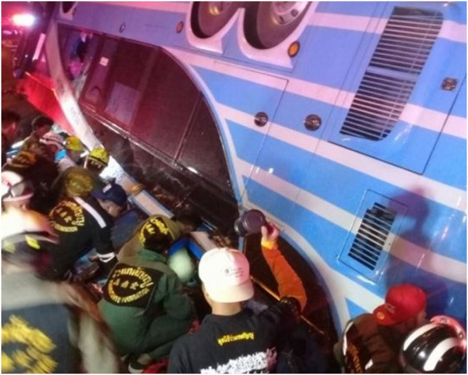 救援人員在翻側的旅巴中救出傷者。