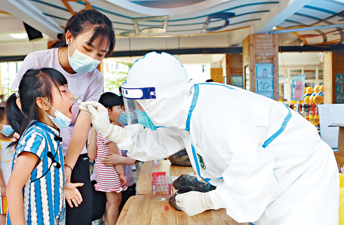 福建泉州医护人员为幼儿检测。