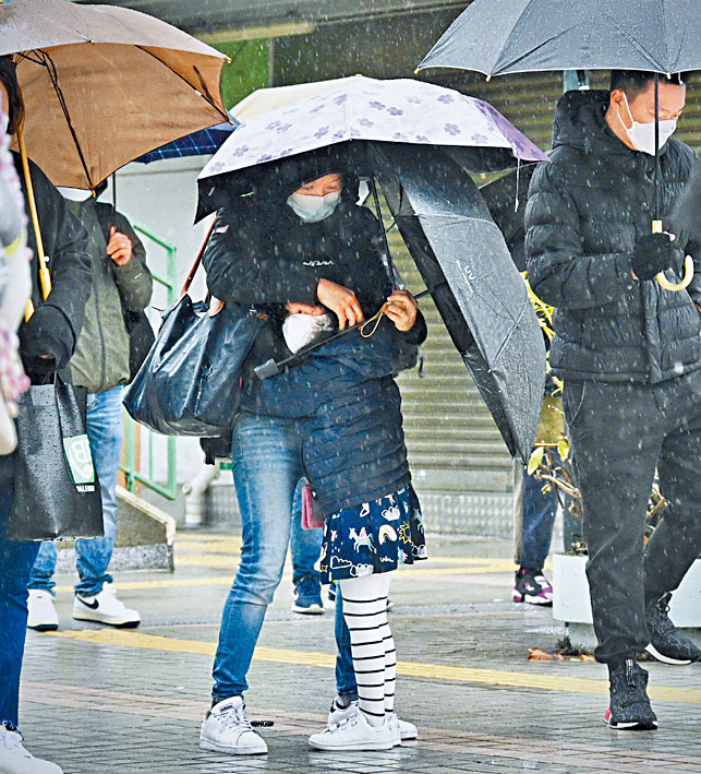 市民携同小孩冒雨于检测中心外轮候。 