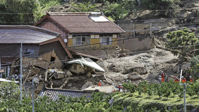 日本南部佐賀縣唐津，救援人員在山泥傾瀉現場搜尋失蹤人員。AP