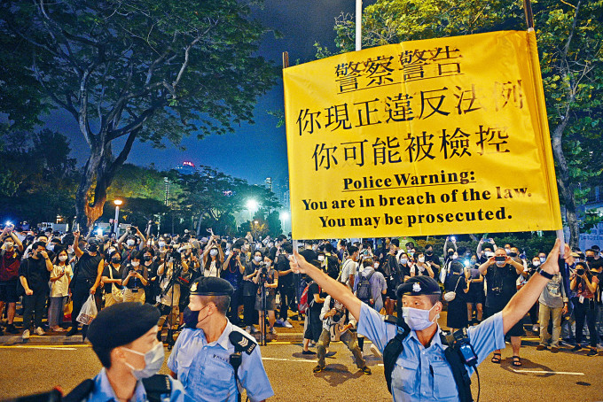 ■警方先后高举黄旗及紫旗，要求在维园外聚集的人群离去。