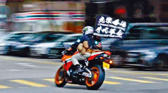 片段顯示被告駕駛插有「光復香港 時代革命」中英標語旗幟的電單車。