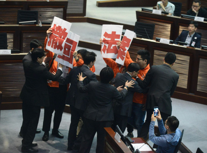 4人在場內舉起「撤回法案」標語衝向主席台位置。