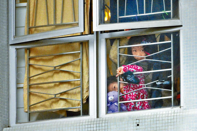 逸葵樓居民被禁足五天，有小孩在屋內倚窗偷看外面情況。