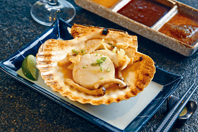 燒帆立貝，肥美肉厚的原隻帆立貝，以明火燒至剛熟，簡單調味凸顯鮮甜味道。