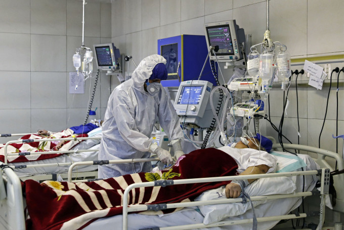 一名医护在伊朗德黑兰医院治疗一名染疫患者。 AP
