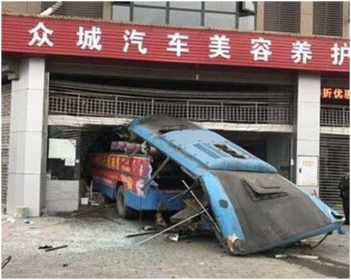 旅遊巴衝入汽車美容店後，整個車頂被削走。網圖