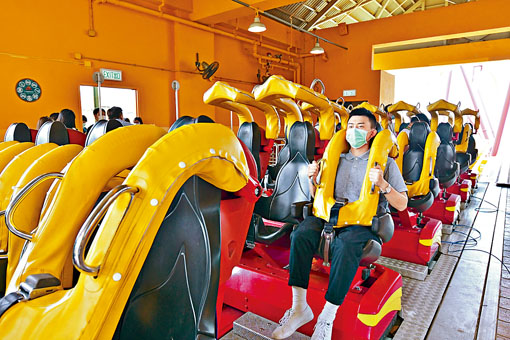 ■海洋公園重開後，互不相識的人士坐機動遊戲要隔開兩個座位。圖為模擬的防疫安排。
