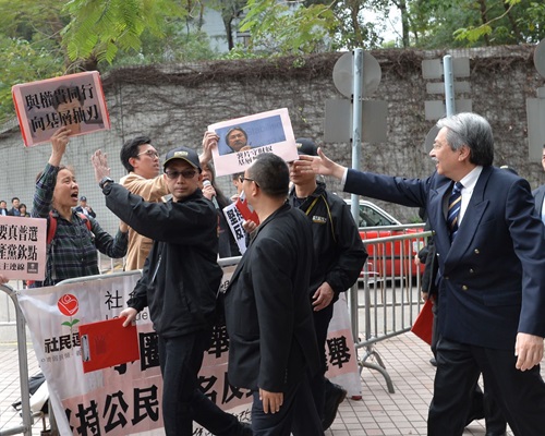 曾俊华接过写有「薯片守财奴」的示威标语。