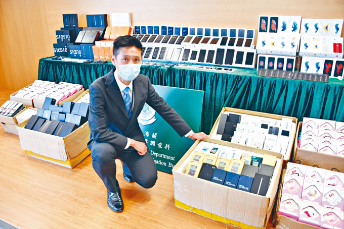 海關司徒志輝展示搜獲冒牌手機及零件。