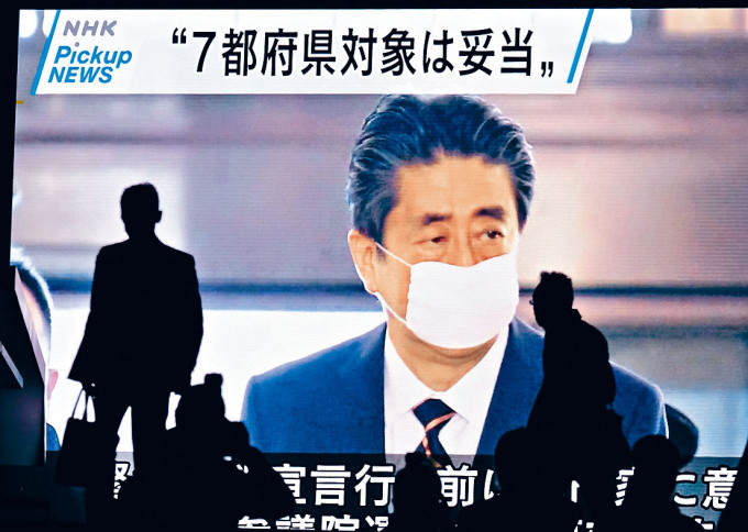 東京的電視屏幕可見安倍戴口罩出席國會會議。