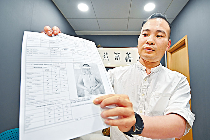 ■梅少峰向記者展示聘請外傭的合約和開支收據。