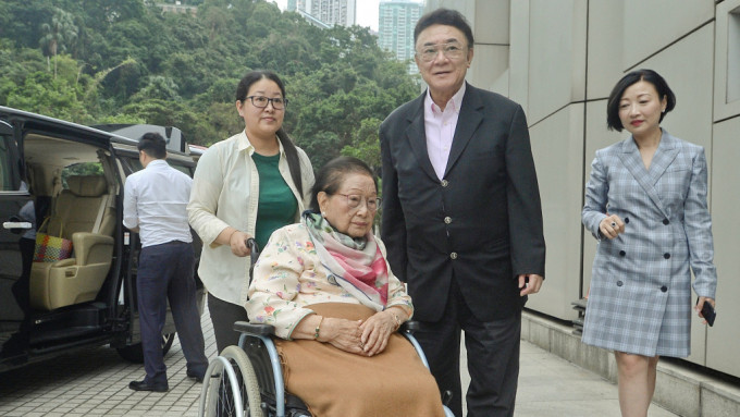罗旭瑞（右二）以母亲罗杜莉君（坐轮椅者）的受权人身份入禀法院。资料图片