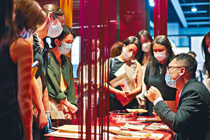 吕智超（右一）于典亚艺博2021向公众介绍修复书画的技术和工具。