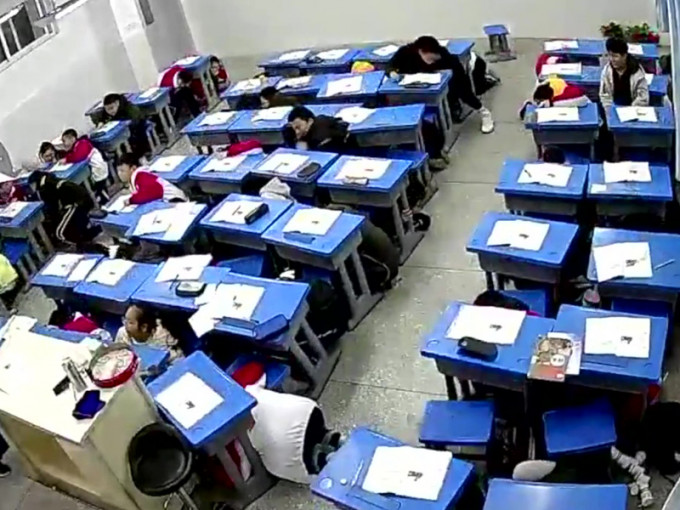 内江威远县一班中学生迅速采取避险措施，全员应声躲避到课桌下。(网图)