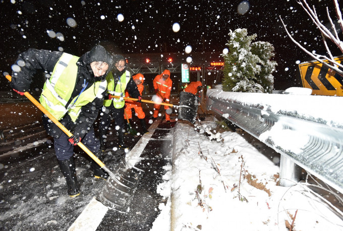 宿扬高速江苏扬州段蜀冈收费站工作人员冒雪清除路面积雪。新华社