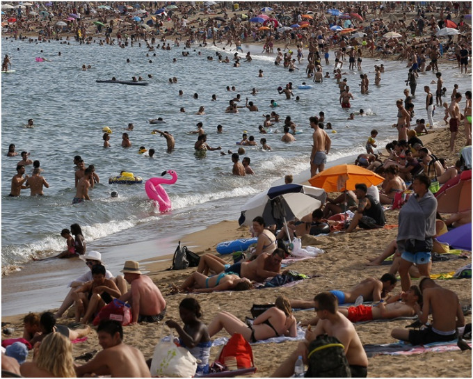 巴塞隆那沙滩迫满游水消暑的市民。 AP